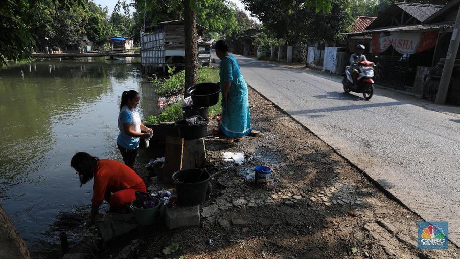 Warga memanfaatkan air sungai untuk mencuci saat musim kemarau berkepanjangan tiba.