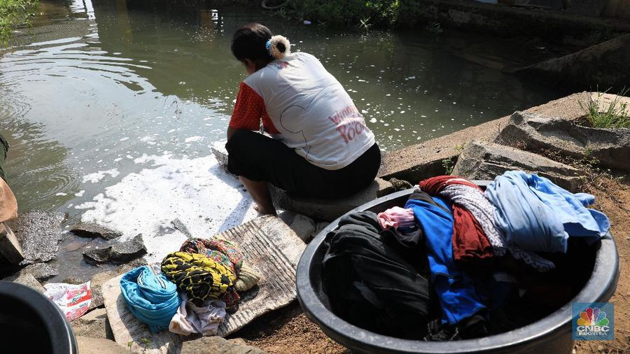 Warga memanfaatkan air sungai untuk mencuci saat musim kemarau berkepanjangan tiba.