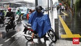Seorang pengguna sepeda motor menggunakan jas hujan jenis ponco di pinggir jalan saat hujan deras mengguyur kawasan Jakarta, termasuk di Bundaran HI, Jalan MH Thamrin, Jakarta Pusat, 1 November 2019. (CNN Indonesia/ Safir Makki)