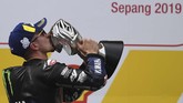 Maverick Vinales mencium trofi juara MotoGP Malaysia 2019 setelah finis pertama di Sirkuit Sepang. Gelar juara ini jadi yang kedua bagi Top Gun setelah finis pertama di MotoGP Belanda 2019. (Photo by Mohd RASFAN / AFP)