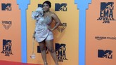 Boitumelo Thulo atau Boity dari Afrika Selatan memilih gaun strapless pendek berwarna silver dengan tambahan detail bunga besar di pundaknya. (CRISTINA QUICLER / AFP)