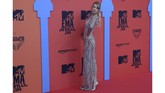 Rose Bertram memilih tampil aman dengan dress bodycon berwarna krem dengan tambahan motif garis aneka warna. (Photo by CRISTINA QUICLER / AFP)