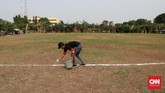 Panitia menaburkan kapur sebagai garis batas sebelum pertandingan Sparta VS Putra Betawi pada laga Porsegeb Cup IV di Stadion Mini Gebyuran, Joglo, Jakarta Barat, Jumat. (CNNIndonesia/Safir Makki)