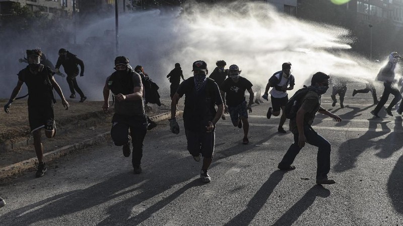 Para demonstran anti-pemerintah berbenturan dengan polisi selama demonstrasi di Santiago, Chili