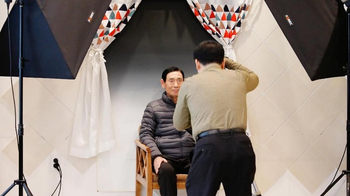 A participant poses for a funeral portrait during a