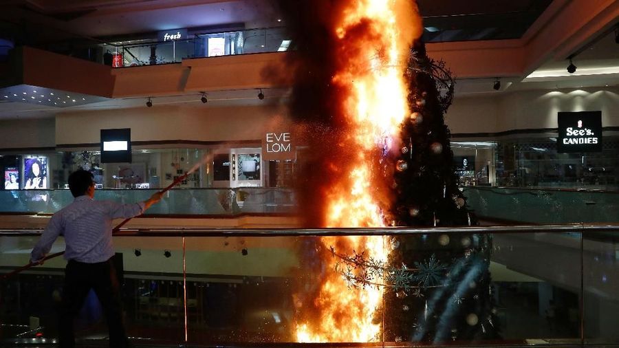 Aksi ekstrim pengunjuk rasa tak hanya di situ saja. Pendemo bakar pohon natal raksasa yang dipajang di dalam mall.