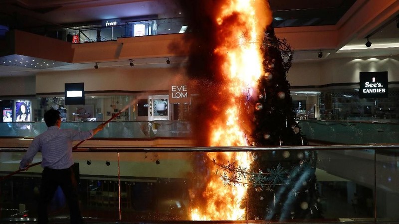 Aksi ekstrim pengunjuk rasa tak hanya di situ saja. Pendemo bakar pohon natal raksasa yang dipajang di dalam mall.
