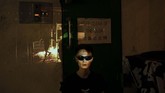 Dalam foto tertanggal 16 Oktober 2019, seorang pedemo Hong Kong bernama Elio berpose untuk sebuah foto saat proyektor menampilkan gambar kerusuhan di negara tersebut. (AP Photo/Felipe Dana)