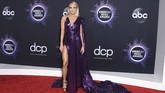 Carrie Underwood memilih gaun berwara ungu metalik dengan cape dan high slit. (Jordan Strauss/Invision/AP)
