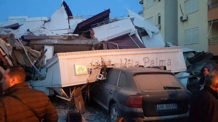People stand next to a damaged hotel after an earthquake, in Durres, western Albania, Tuesday, Nov. 26, 2019. A powerful earthquake shook Albania early Tuesday, causing at least minor damage. (AP Photo)