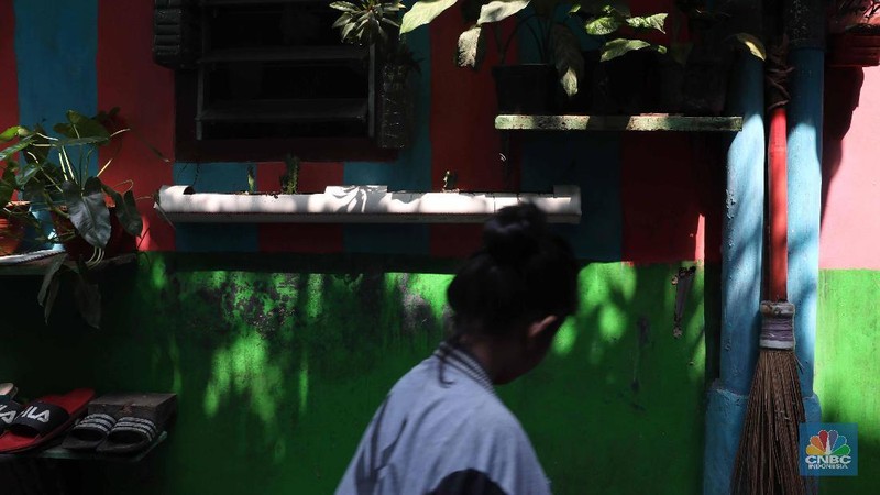 Pelajar melintas di kawasan kampung warna-warni Penas, Jakarta, Rabu (27/11/2019).