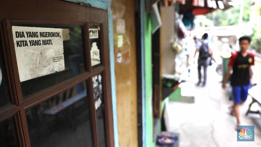 Pelajar melintas di kawasan kampung warna-warni Penas, Jakarta, Rabu (27/11/2019).