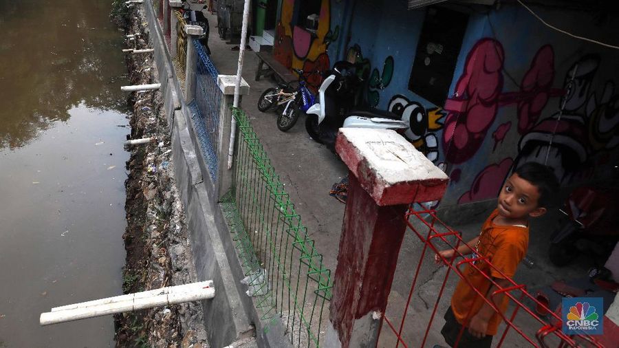 Pelajar melintas di kawasan kampung warna-warni Penas, Jakarta, Rabu (27/11/2019).