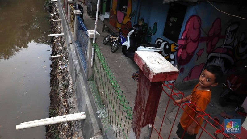 Pelajar melintas di kawasan kampung warna-warni Penas, Jakarta, Rabu (27/11/2019).