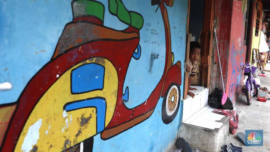Pelajar melintas di kawasan kampung warna-warni Penas, Jakarta, Rabu (27/11/2019).