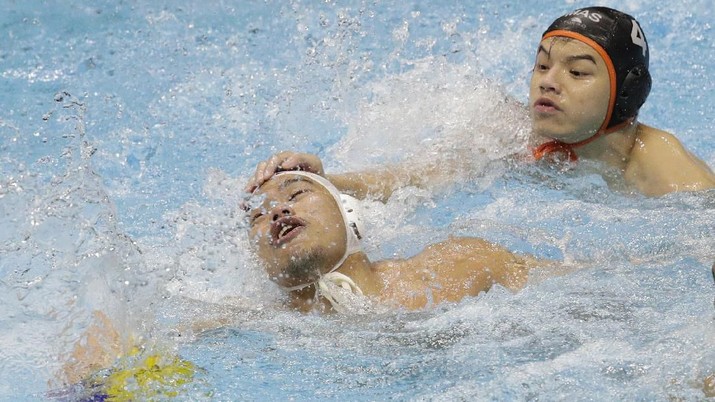 Indonesia's Delvin Fellicino, left, scrambles for ball possession against Malaysia's Xiang Yi Toh during their men's water polo match at the 30th South East Asian Games in New Clark City, Tarlac province, northern Philippines on Friday, Nov. 29, 2019. (AP Photo/Aaron Favila)