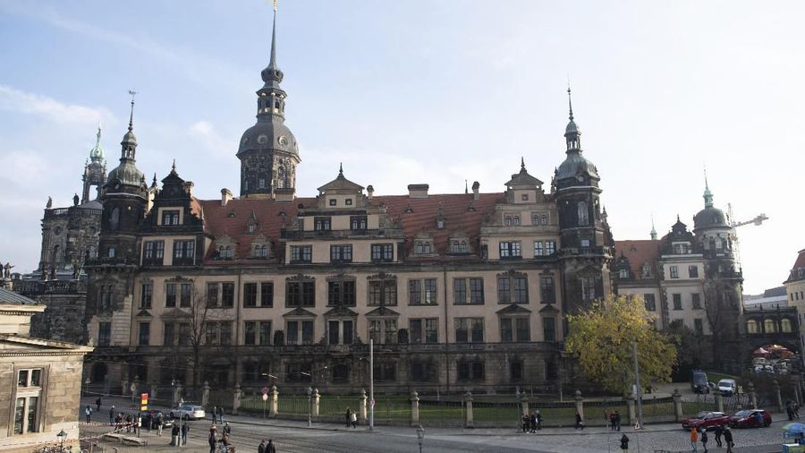 People stand in front of the Residenzschloss, Residence Palace, building with the Green Vault in Dresden Monday, Nov. 25, 2019. Authorities in Germany say thieves have carried out a brazen heist at Dresden’s Green Vault, one of the world’s oldest museum containing priceless treasures from around the world. (Sebastian Kahnert/dpa via AP)