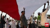 Massa aksi Reuni 212 membentangkan Bendera Merah Putih di Monas, Jakarta, Senin (2/12). (CNN Indonesia/Safir Makki)