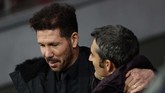 Pelatih Atletico Madrid Diego Simeone (kiri) berbicara dengan pelatih Barcelona Ernesto Valverde sebelum laga Liga Spanyol di Stadion Wanda Metropolitano, Minggu (1/12) malam waktu setempat. (AP Photo/Manu Fernandez)
