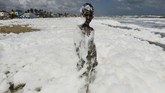 Beberapa perusahaan farmasi membuang limbah yang tidak diolah ke sungai Cooum. Ini merupakan salah satu alasan di balik banyaknya busa di Pantai Marina, Chennai. (Photo by Arun SANKAR/AFP).