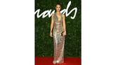 Rosie Huntington-Whiteley mengenakan gaun berwarna emas hangat dengan bukaan punggung karya Bottega Veneta. (Photo by Joel C Ryan/Invision/AP)