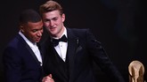 Pemain Juventus dan timnas Belanda Matthijs de Ligt meraih penghargaan trofi Kopa yang diberikan oleh penyerang Paris Saint-Germain, Kylian Mbappe saat penghargaan Ballon d'Or 2019. (Photo by FRANCK FIFE / AFP)