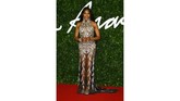 Naomi Campbell mengenakan gaun hitam semi transparan berhias kristal dengan garis leher yang tinggi. (Photo by Joel C Ryan/Invision/AP)