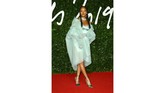 Rihanna mengenakan gaun mini berbahan satin berwarna hijau mint yang dibalut dengan mantel transparan karya Fenty. Dipadukan dengan perhiasan rancangan Fabio Salini. (Photo by Joel C Ryan/Invision/AP)