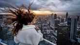 Rambut melambai seorang turis muda Prancis di platform Main Tower di Frankfurt, Jerman saat matahari terbenam, Kamis (28/11). (AP Photo/Michael Probst)