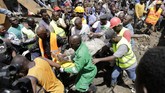 Tim SAR membopong seorang yang dievakuasi dari runtuhan bangunan enam lantai di Tasia Embakasi, Kenya, Jumat (6/12). (AP Photo/Khalil Senosi)