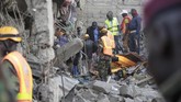 Tim SAR bekerja mencari korban di antara bangunan enam lantai yang roboh di Tasia Embakasi, Kenya, Jumat (6/12). (AP Photo/Khalil Senosi)