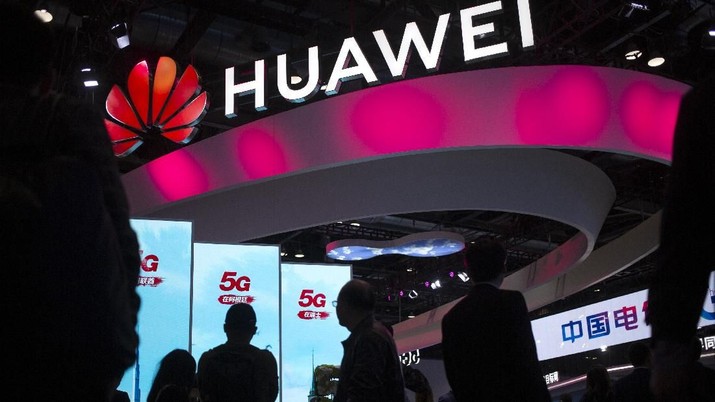 In this Oct. 31, 2019, photo, attendees walk past a display for 5G services from Chinese technology firm Huawei at the PT Expo in Beijing. Chinese tech giant Huawei is asking a U.S. federal court to throw out a rule that bars rural phone carriers from using government money to purchase its equipment on security grounds, announced Thursday, Dec. 5, 2019. (AP Photo/Mark Schiefelbein)