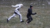 Para 'setan' memakai topeng buatan sendiri dari kulit domba dan bepergian dengan makhluk putih yang mewakili kematian dengan membawa sabit. (AP Photo/Petr David Josek)