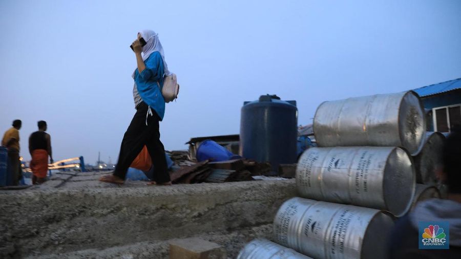 Aktivitas warga Muara Baru saat senja di kawasan pemukiman kumuh Muara Baru, Jakarta Utara, Rabu (11/12). Gubernur DKI Jakarta Anies Baswedan menyatakan bahwa setengah dari warganya tidak memiliki rumah sendiri. 
