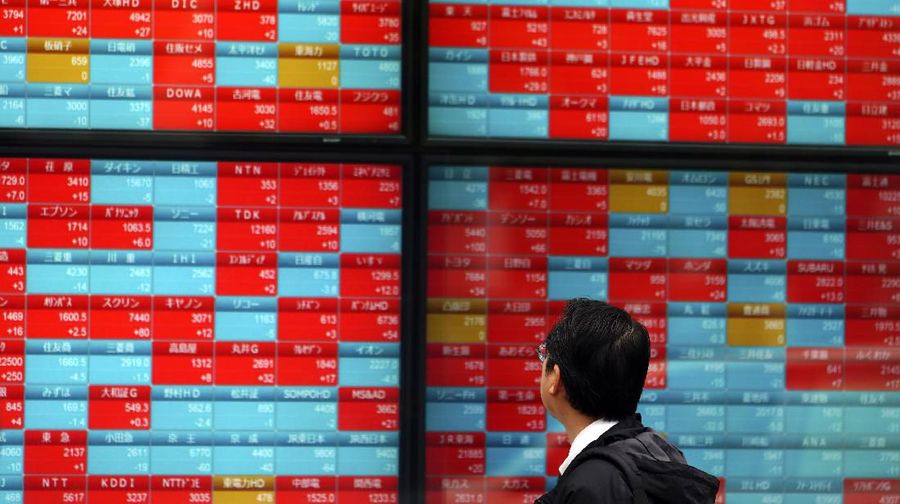 A man looks at an electronic stock board showing Japan's Nikkei 225 index at a securities firm in Tokyo Wednesday, Dec. 11, 2019. (AP Photo/Eugene Hoshiko)