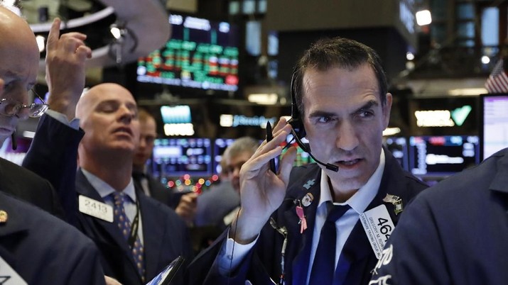 Trader Gregory Rowe, right, works on the floor of the New York Stock Exchange, Wednesday, Dec. 11, 2019. Stocks are opening mixed on Wall Street following news reports that US President Donald Trump might delay a tariff hike on Chinese goods set to go into effect this weekend. (AP Photo/Richard Drew)