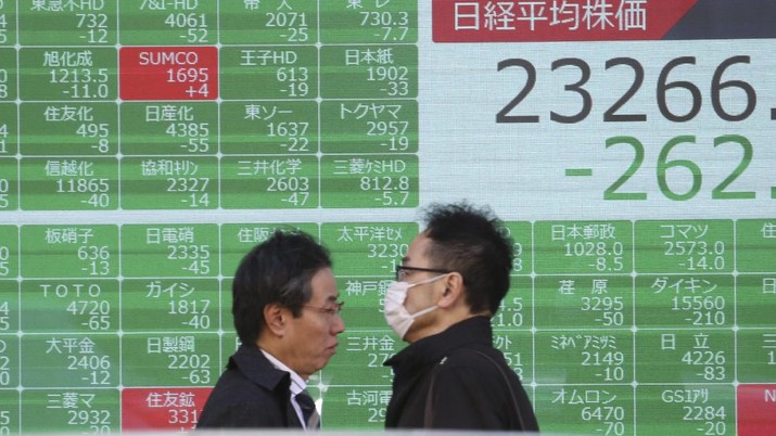People walk by an electronic stock board of a securities firm in Tokyo, Tuesday, Dec. 3, 2019. Asian shares slipped Tuesday, following a drop on Wall Street amid pessimism over U.S.-China trade tensions. (AP Photo/Koji Sasahara)
