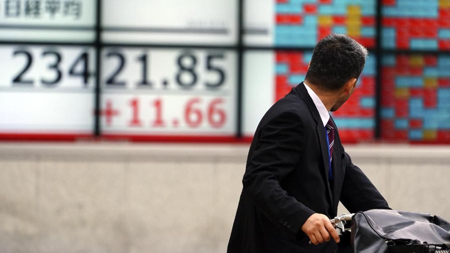A man looks at an electronic stock board showing Japan's Nikkei 225 index at a securities firm in Tokyo Wednesday, Dec. 11, 2019. Asian stock markets have risen following a report President Donald Trump plans to delay a tariff hike on Chinese goods. (AP Photo/Eugene Hoshiko)