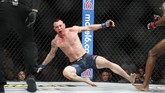 Momen ketika Colby Covington jatuh setelah dipukul Kamaru Usman di pengujung ronde kelima. Beberapa saat kemudian Usman dinyatakan menang TKO. (AP Photo/John Locher)