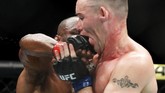 Kamaru Usman berhasil memukul Colby Covington dengan telak pada ronde ketiga. Pukulan itu membuat Covington kesakitan. (AP Photo/John Locher)