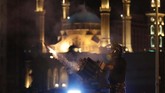 Polisi dilaporkan dilempari botol air minum dan petasan saat menjaga gedung parlemen yang menjadi titik kumpul pedemo. (AP Photo/Hussein Malla)
