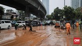 Petugas membersihkan endapan lumpur yang terbawa banjir di sekitar jalan dr susilo. Jakarta, Selasa, 17 Desember 2019. Hujan deras di sekitar Jakarta menyebabkan sejumlah genangan di jalan protokol. (CNNIndonesia/Adhi Wicaksono).