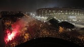 Polisi anti-huru hara bentrok dengan demonstran pada Rabu (18/12) malam di jalan dekat stadion Camp Nou saat laga Barcelona kontra Real Madrid. (AP Photo/Joan Mateu)