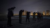 Para pekerja memotong blok es di sungai Songhua yang membeku. Sungai ini berada di Harbin, Provinsi Heilongjiang, China. (AFP/Noel Celis)