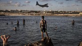 Para tentara menikmati hari libur, sementara warga Somalia melihat dari pantai di dekat pangkalan militer di Mogadishu. (AFP/Luis Tato)