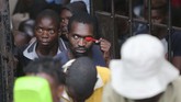 Seorang pria menutupi wajahnya dari bidikan kamera dengan sebuah sendok plastik ketika hadir di persidangan Marry Chiwenga, istri dari wakil presiden Zimbabwe, didakwa membunuh istrinya. (AP/Tsvangirayi Mukwazhi)
