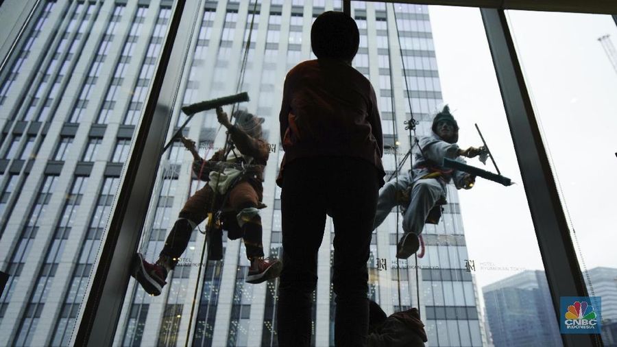 Window cleaners dressed as zodiac animal of boar and rat clean the glass exterior of a hotel Thursday, Dec. 19, 2019, in Tokyo. During the year end 