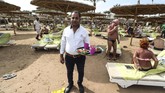 Seorang pegawai resor Hurghada di tepi Laut Merah Mesir menyediakan makanan di atas nampan terbuat dari arkilik dan kayu sebagai alternatif dari plastik. (Mohamed el-Shahed / AFP)