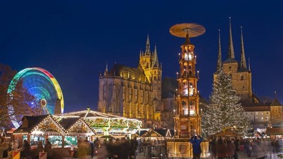 Perayaan di Jerman (AP Photo/Jens Meyer) In this picture taken with a long time exposure people walk along the Christmas Fair in front of the Mariendom (Cathedral of Mary) and St. Severi's Church in Erfurt, central Germany, Friday, Dec. 20, 2019. The Erfurt Christmas Market is one of the most beautiful Christmas Markets in the whole of Germany. The square is beautifully decorated with a huge, candle-lit Christmas tree and a large, hand-carved wooden creche. (AP Photo/Jens Meyer)