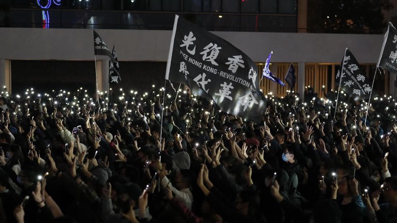 Peserta demonstrasi Hong Kong menyalakan senter dari smartphone.